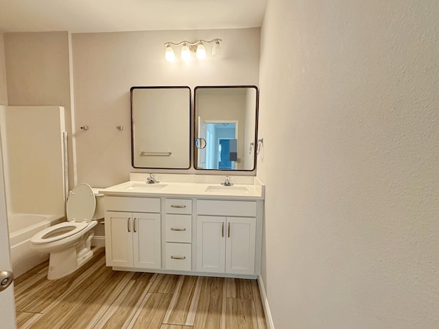 full bathroom with hardwood / wood-style flooring, vanity, toilet, and shower / washtub combination