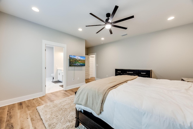 bedroom featuring light wood-type flooring, ensuite bath, and ceiling fan