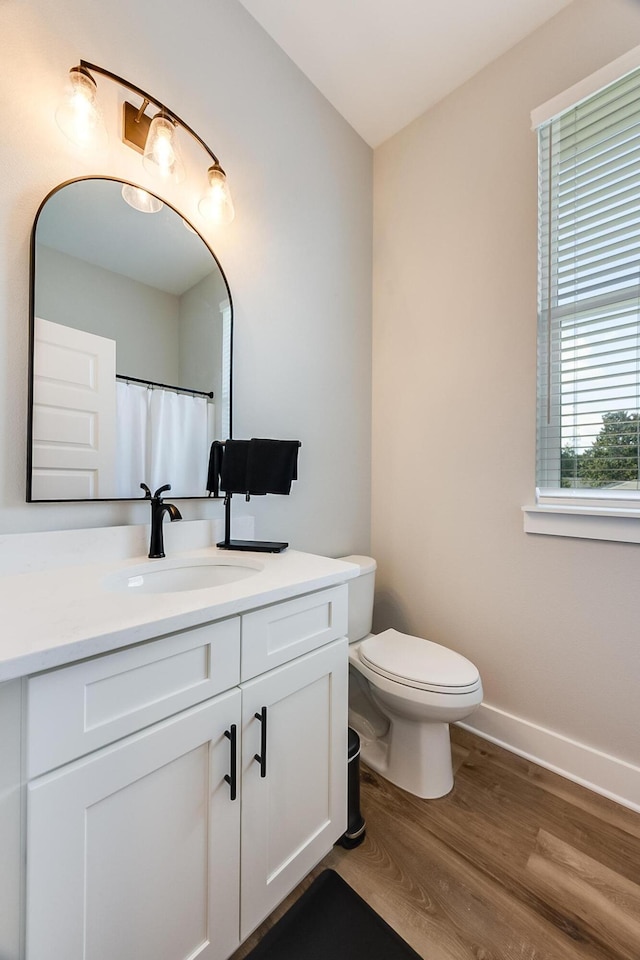 bathroom with hardwood / wood-style floors, vanity, and toilet