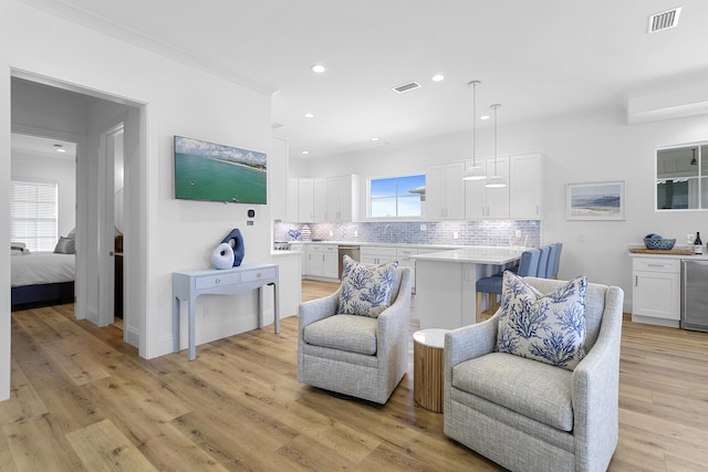 living area with light hardwood / wood-style floors and beverage cooler