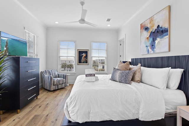 bedroom with ceiling fan, crown molding, and light hardwood / wood-style flooring