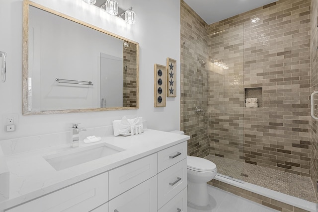 bathroom with tile patterned floors, vanity, toilet, and walk in shower