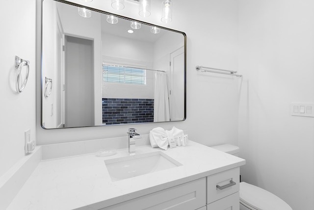 bathroom with curtained shower, vanity, and toilet