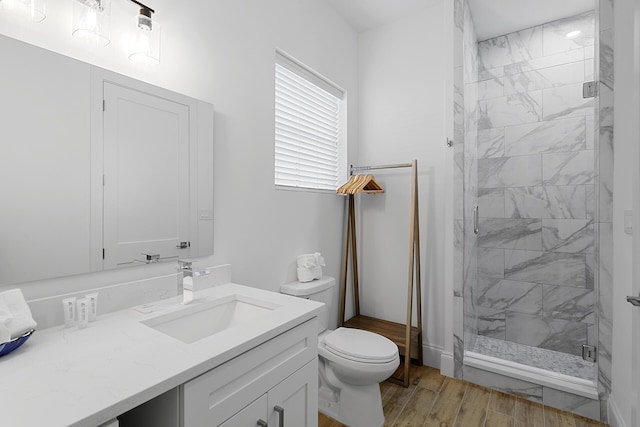 bathroom featuring hardwood / wood-style floors, vanity, toilet, and a shower with door