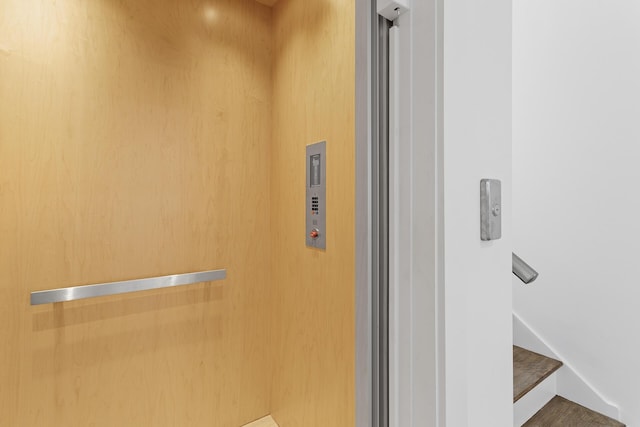 interior details with elevator and wood-type flooring