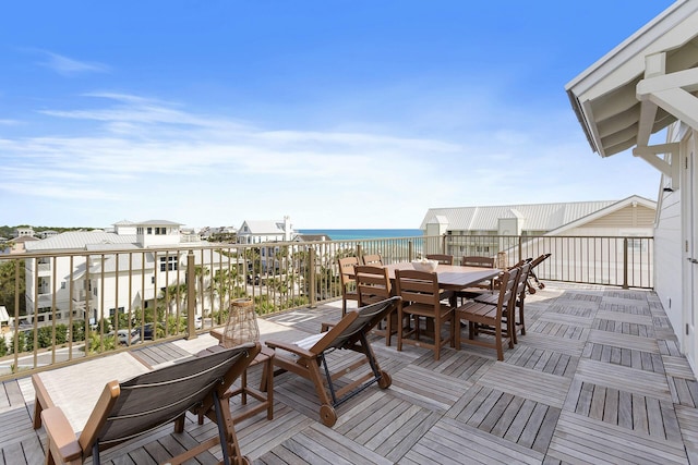 wooden terrace featuring a water view and a beach view