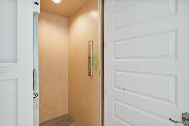 interior details featuring wood-type flooring and elevator