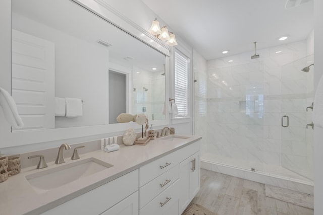 bathroom featuring wood-type flooring, vanity, and an enclosed shower