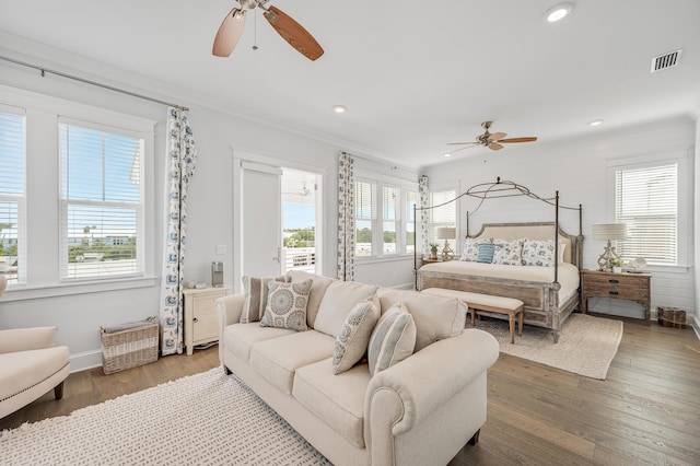 bedroom with crown molding, ceiling fan, and dark wood-type flooring