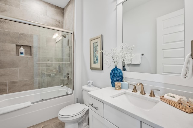 full bathroom featuring toilet, combined bath / shower with glass door, and vanity