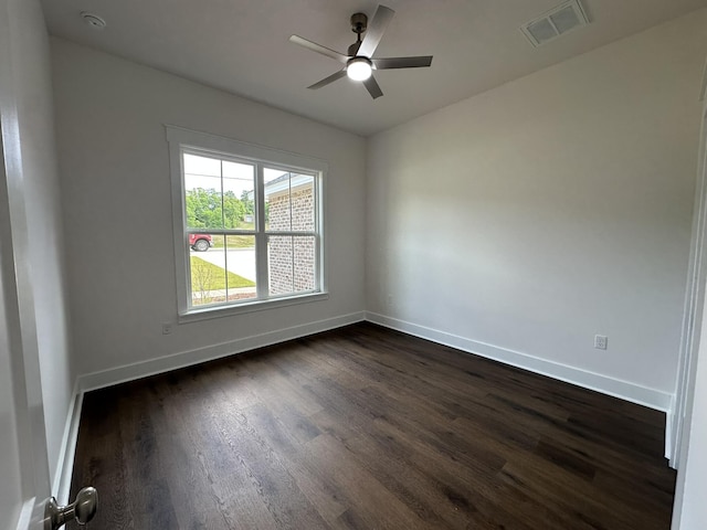 spare room featuring baseboards, a ceiling fan, and dark wood-type flooring
