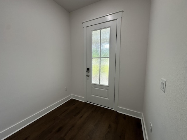 doorway featuring dark wood finished floors and baseboards