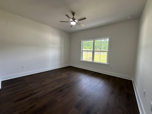 unfurnished room with dark wood-style floors, ceiling fan, and baseboards