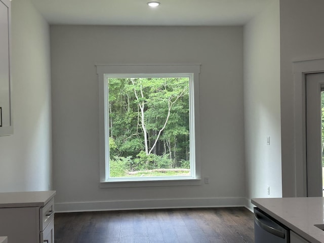 unfurnished dining area with recessed lighting, dark wood-style floors, and baseboards