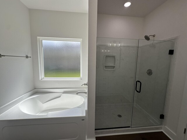 bathroom with a bath and a stall shower