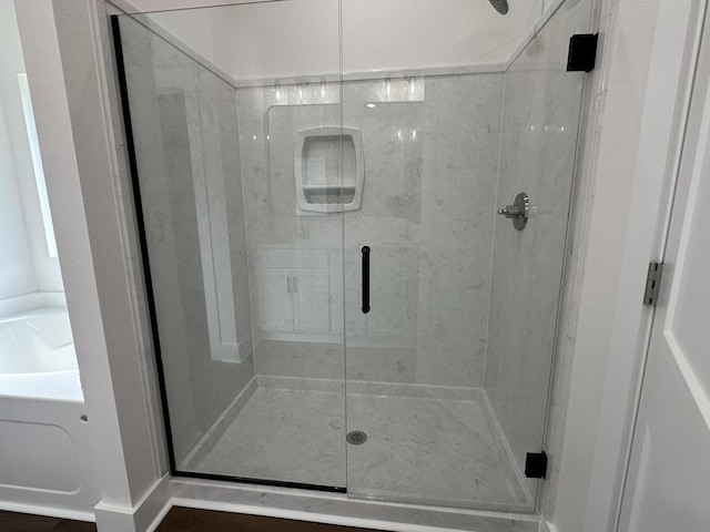 bathroom with a shower stall and a garden tub