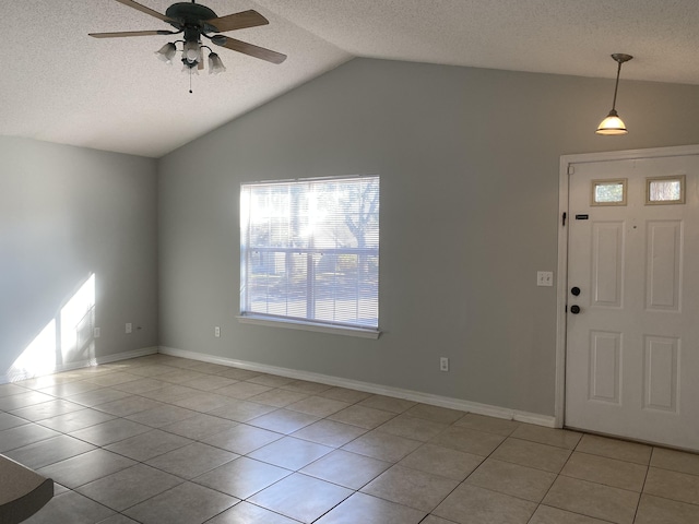 tiled entryway featuring ceiling fan, a textured ceiling, and vaulted ceiling