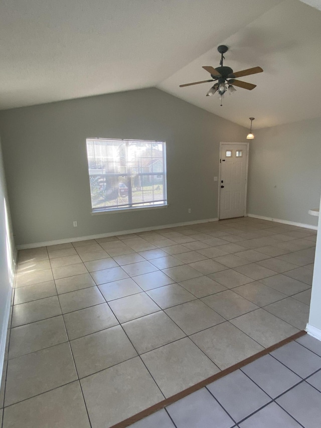 tiled empty room with ceiling fan and lofted ceiling