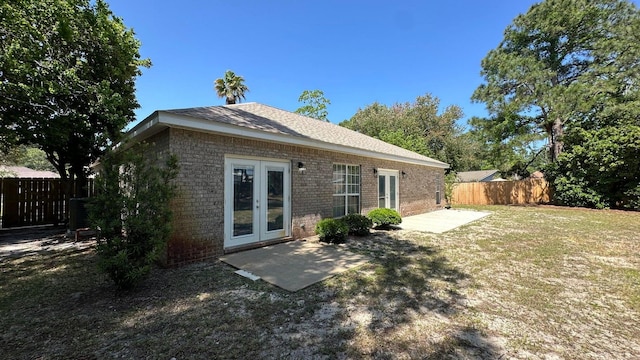 rear view of property with a patio area, french doors, and a lawn