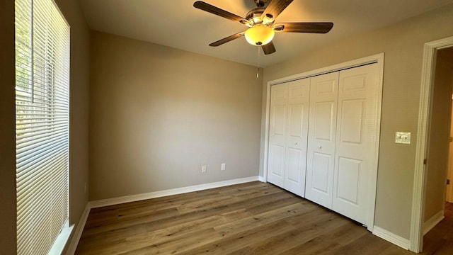 unfurnished bedroom with a closet, ceiling fan, and dark hardwood / wood-style floors