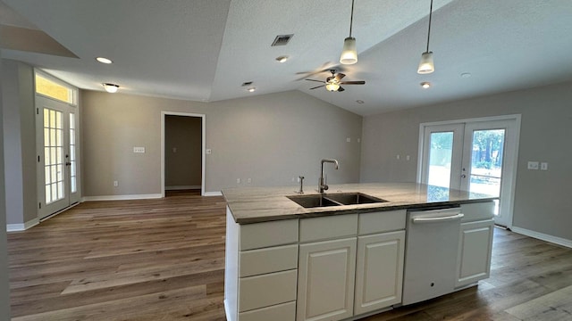 kitchen featuring dishwasher, french doors, lofted ceiling, white cabinets, and sink