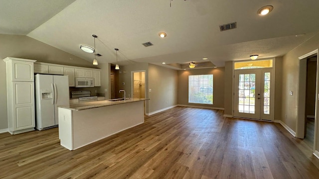 kitchen featuring white appliances, an island with sink, ceiling fan, sink, and white cabinetry