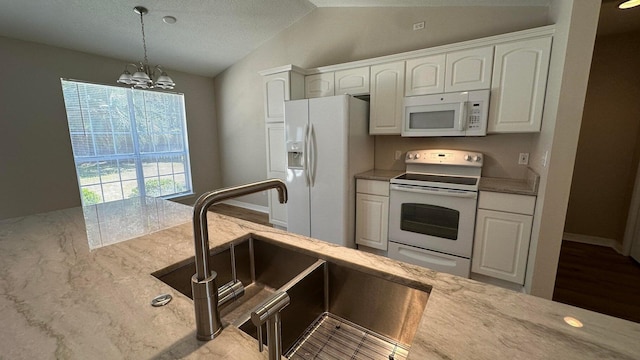 kitchen with sink, white appliances, a chandelier, and white cabinets