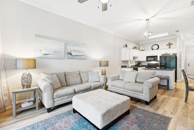 living room featuring light wood-type flooring, ceiling fan with notable chandelier, and ornamental molding