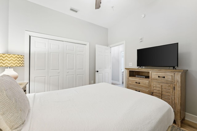 bedroom featuring hardwood / wood-style flooring, ceiling fan, and a closet