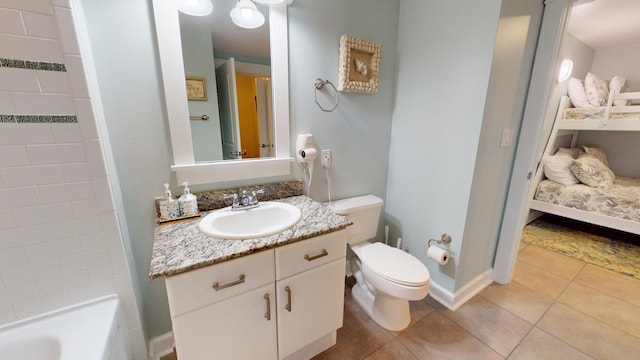 bathroom with toilet, vanity, and tile patterned floors