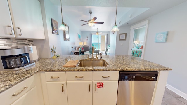 kitchen with decorative backsplash, white cabinetry, stainless steel dishwasher, and light stone counters