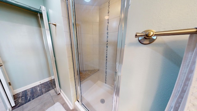 bathroom with tile patterned flooring and a shower with shower door