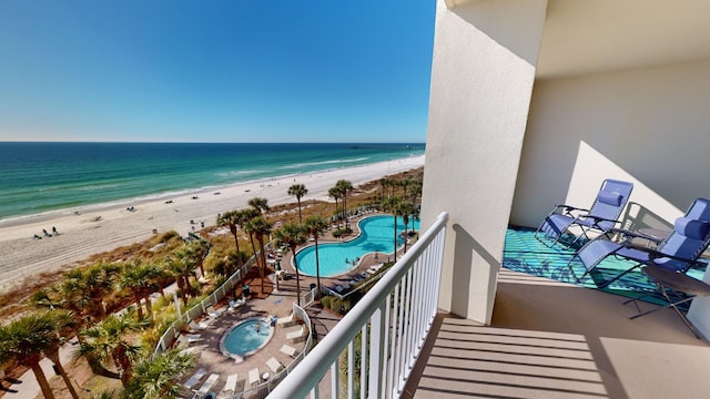 balcony with a water view and a view of the beach