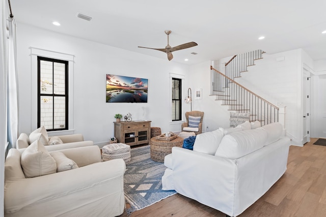 living room with light hardwood / wood-style flooring and ceiling fan