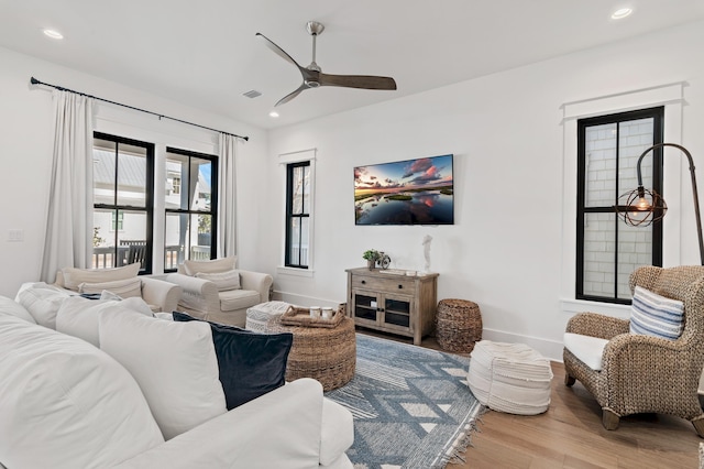 living room featuring ceiling fan and hardwood / wood-style flooring