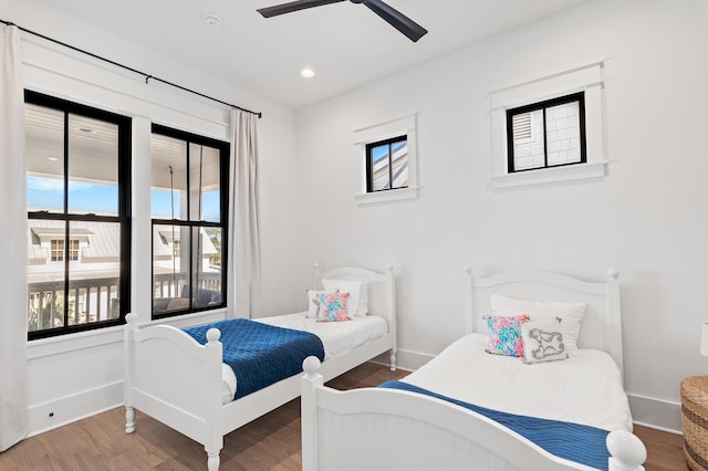 bedroom featuring multiple windows, ceiling fan, and wood-type flooring