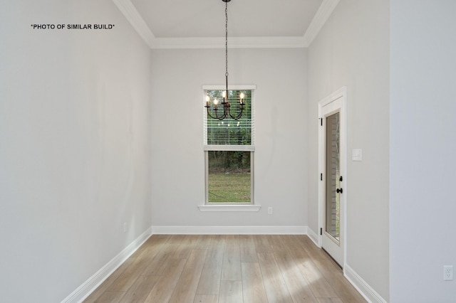 unfurnished dining area featuring crown molding, baseboards, a notable chandelier, and light wood finished floors