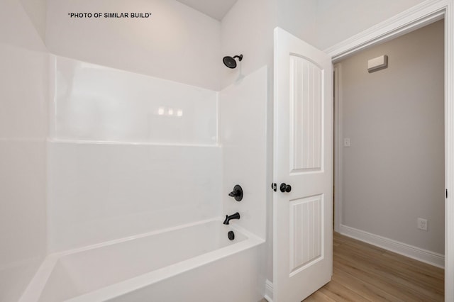 bathroom featuring shower / bath combination, baseboards, and wood finished floors