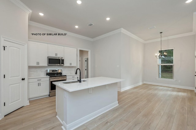 kitchen featuring an island with sink, stainless steel appliances, light countertops, white cabinetry, and a sink