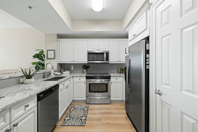 1111 Santa Rosa Blvd Unit 106, Fort Walton Beach, FL 32548 - kitchen featuring light stone countertops, stainless steel appliances, sink, light hardwood / wood-style floors, and white cabinetry