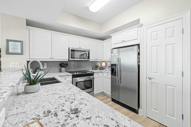 1111 Santa Rosa Blvd Unit 106, Fort Walton Beach, FL 32548 - kitchen with light stone countertops, sink, white cabinetry, and stainless steel appliances