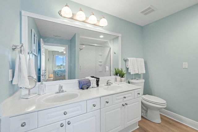 1111 Santa Rosa Blvd Unit 106, Fort Walton Beach, FL 32548 - bathroom with vanity, hardwood / wood-style flooring, ceiling fan, toilet, and an enclosed shower