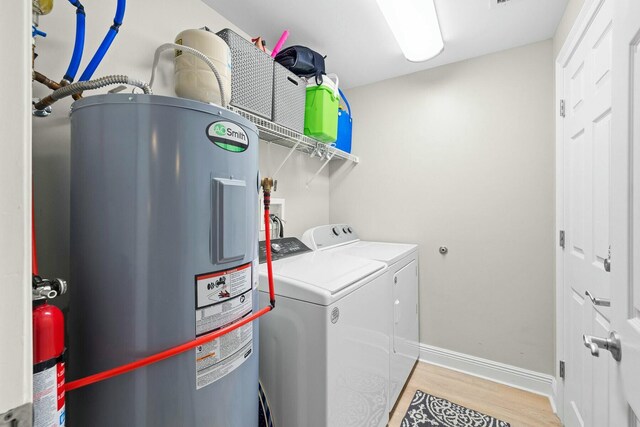 1111 Santa Rosa Blvd Unit 106, Fort Walton Beach, FL 32548 - clothes washing area with washer and dryer, light wood-type flooring, and electric water heater