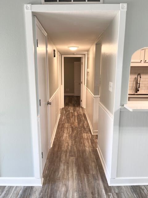 hall with dark hardwood / wood-style flooring and sink