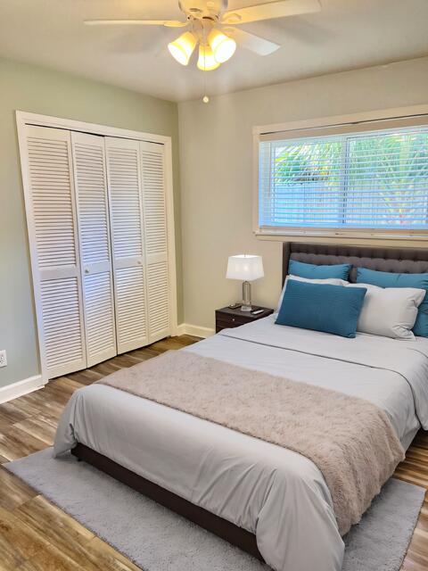 bedroom featuring ceiling fan, a closet, and hardwood / wood-style flooring