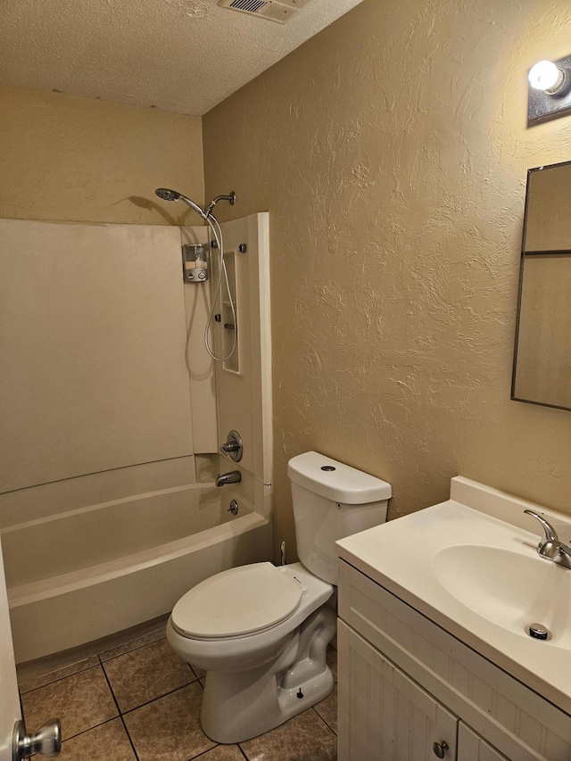 full bathroom with washtub / shower combination, tile patterned flooring, a textured ceiling, toilet, and vanity