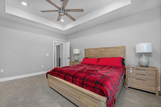 bedroom with a tray ceiling and ceiling fan