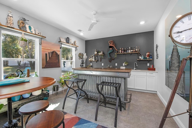 kitchen featuring white cabinetry, sink, and ceiling fan