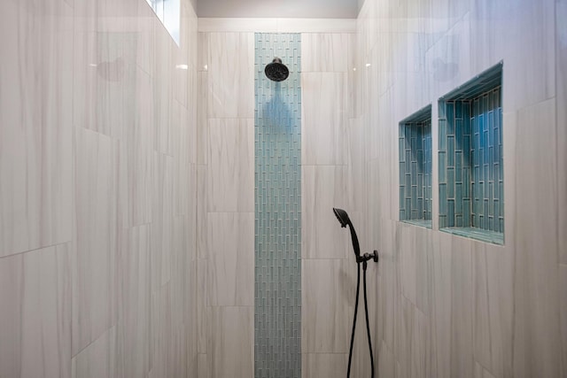 interior details featuring tiled shower