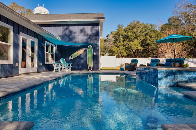 view of pool featuring a jacuzzi, french doors, and a patio